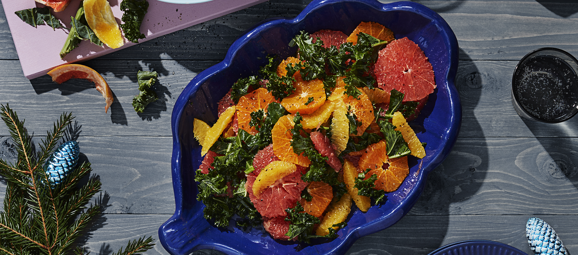 citrussallad med grapfrukt, apelsin och grönkål i en skål serverad på ett bord