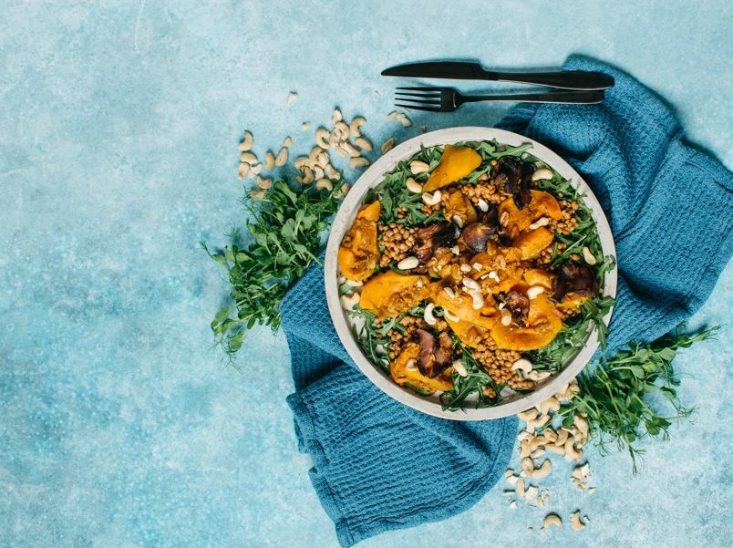 Kanēļa ķirbja salāti pasniegti traukā uz galda