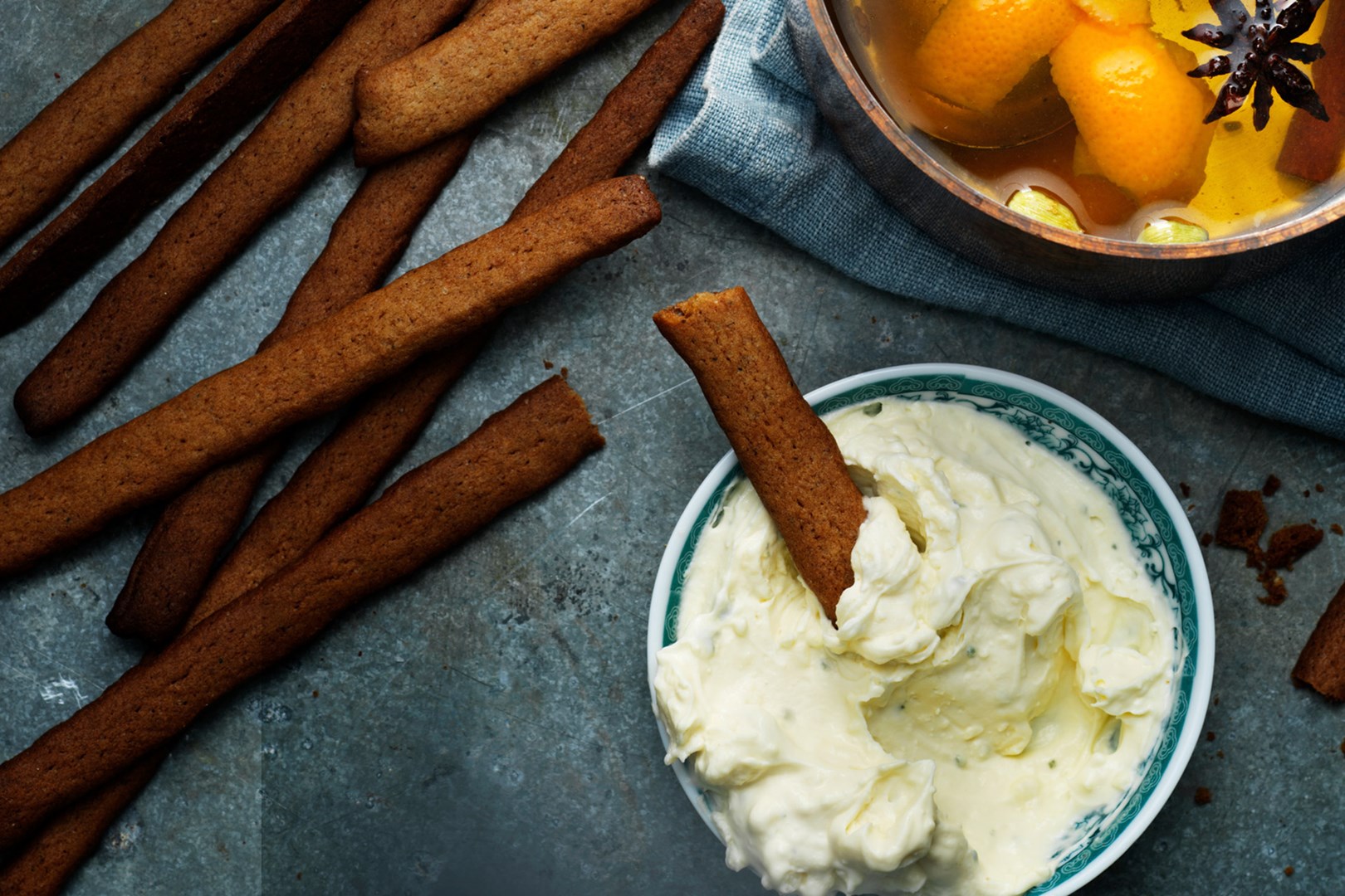 Sticks of gingerbread grissini with a bowl of whipped blue chees