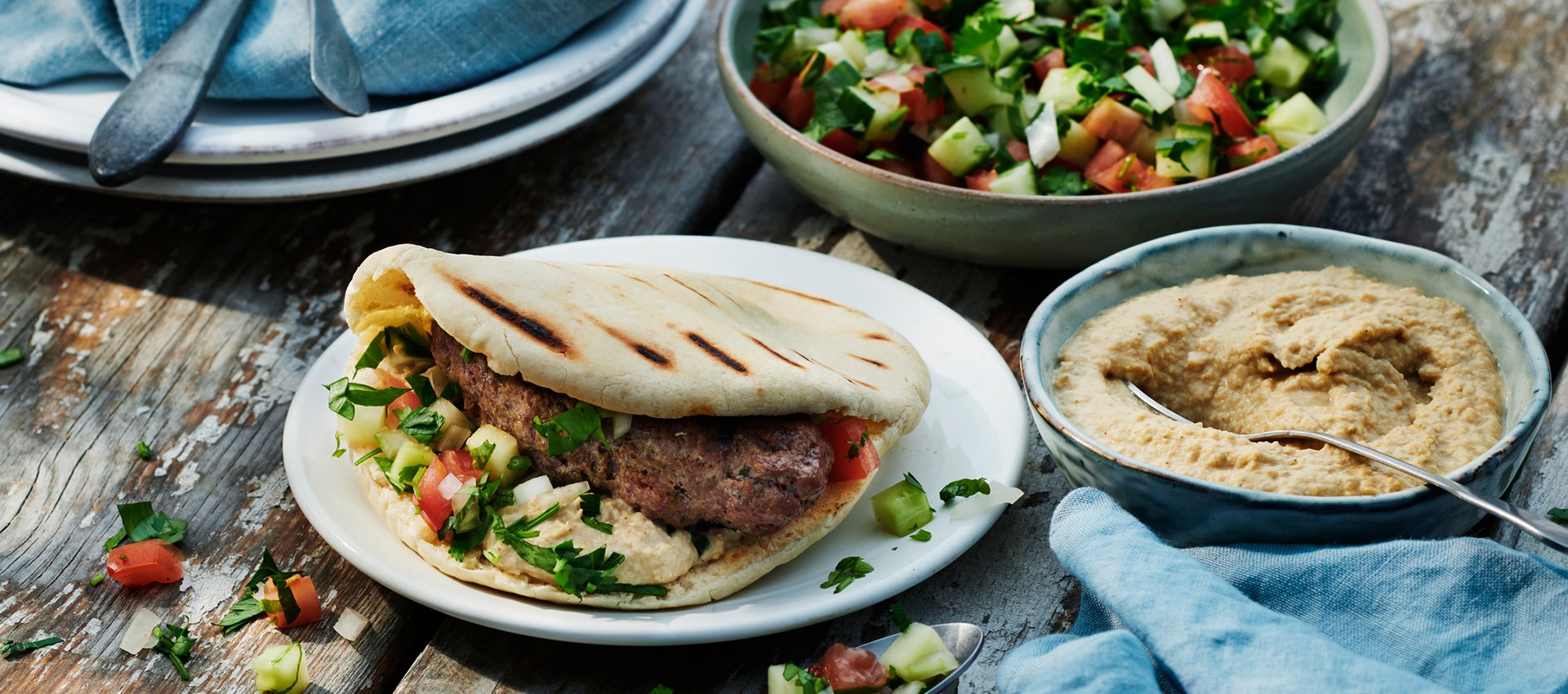 Shish kebab med pitabröd, hummus och hackad tomat- och gurksallad