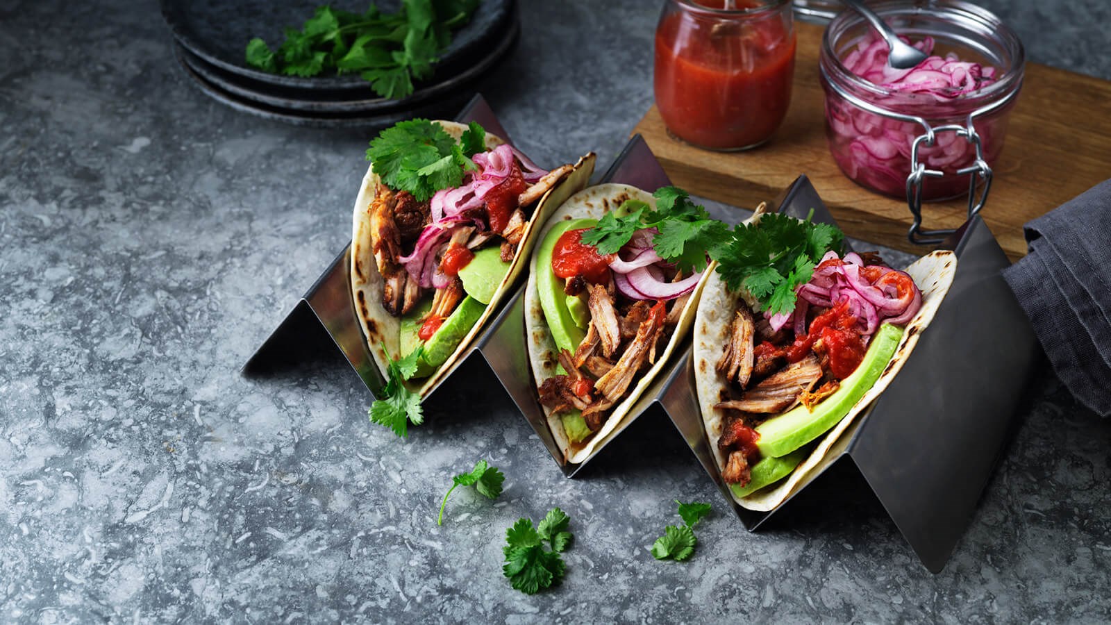 Three pulled pork taco on a tray