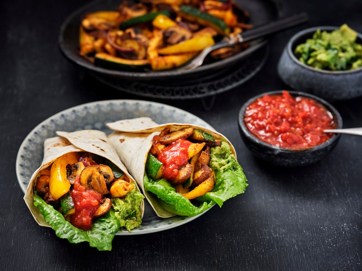 2 fajitas op ene bord gevuld met paddenstoelen en kip