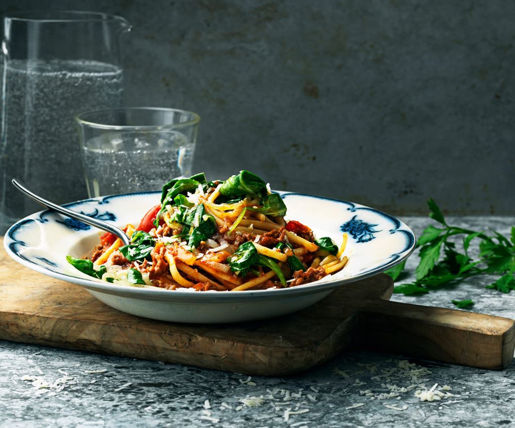 Bolognese met knoflook en spinazie op een bord