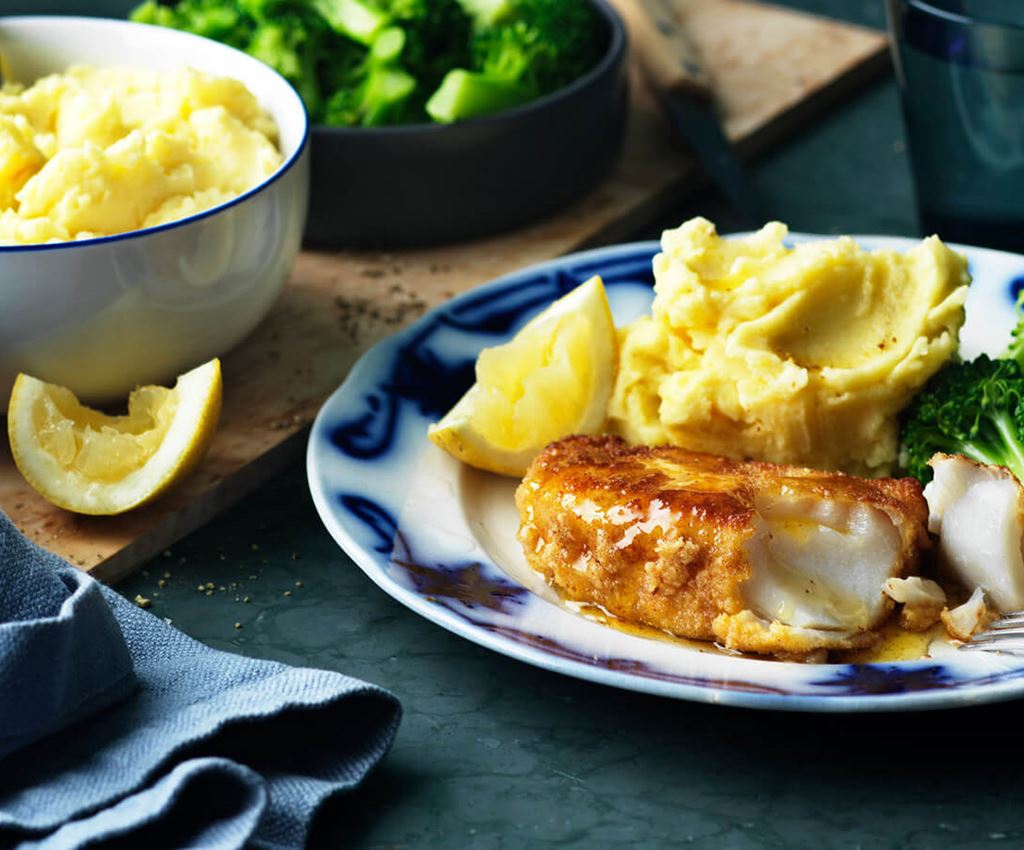 Fisk, potatismos och broccoli upplagt på en tallrik