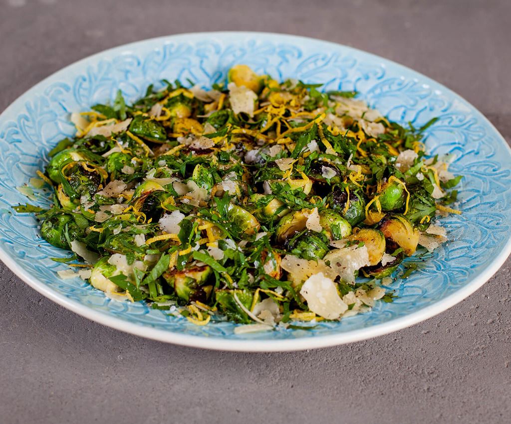 Stekt brysselkål med gremolata och parmesan på ett blått serveringsfat