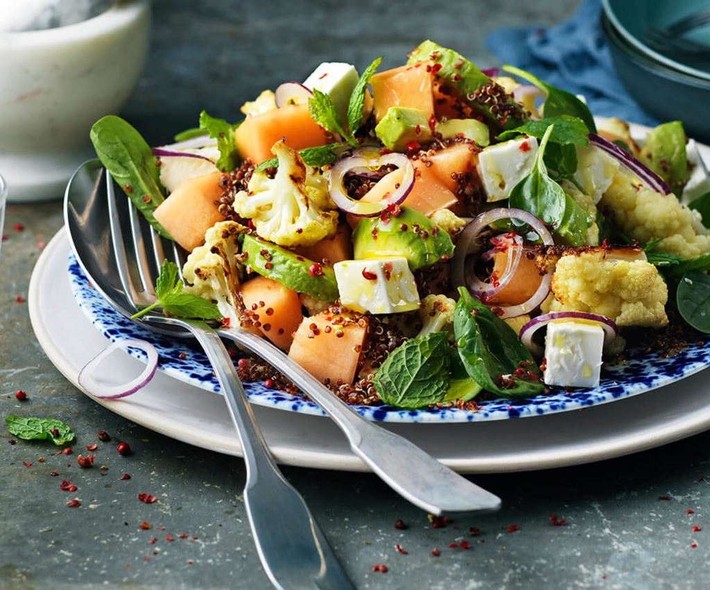 Meloen en feta salade met spinazie en roze pepers