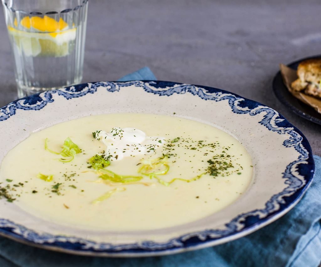 En tallrik med potatis- och purjolökssoppa toppad med crème fraiche