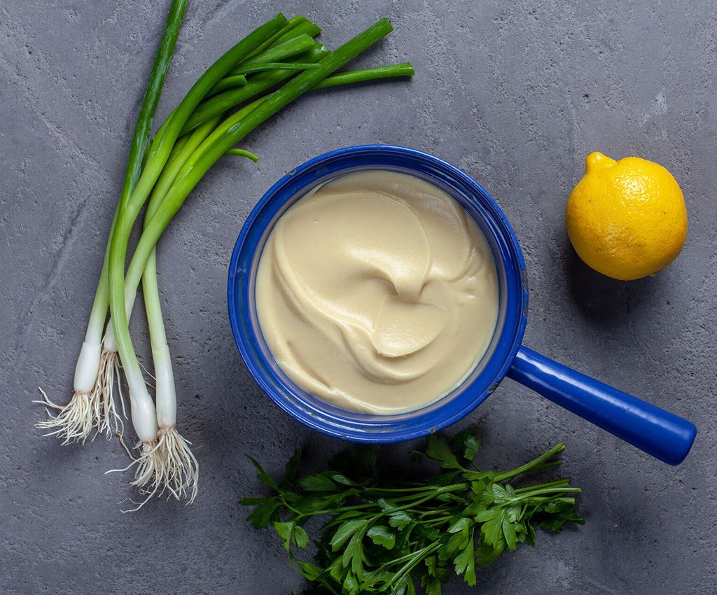 Blå kastrull med rotselleripuré omgiven av citron och sticklök