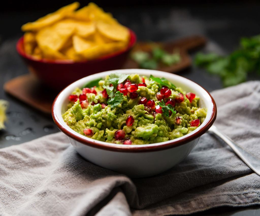 Guacamole med granaäppelkärnor i en skål