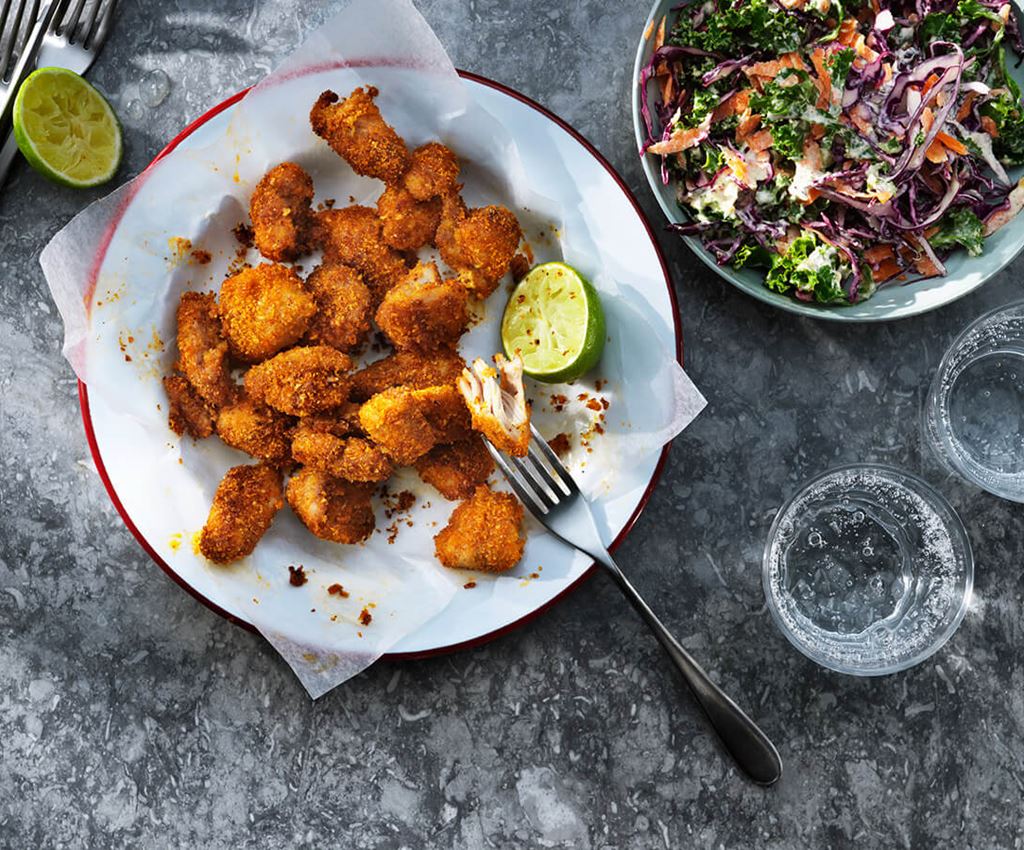 Krispiga kycklingnuggets och en skål med coleslaw